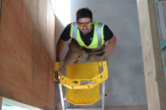 Bailey P170 Job Station FS13538 Aluminium Platform Ladder with man in high-vis and glasses climbing, tools stored in yellow safety rail